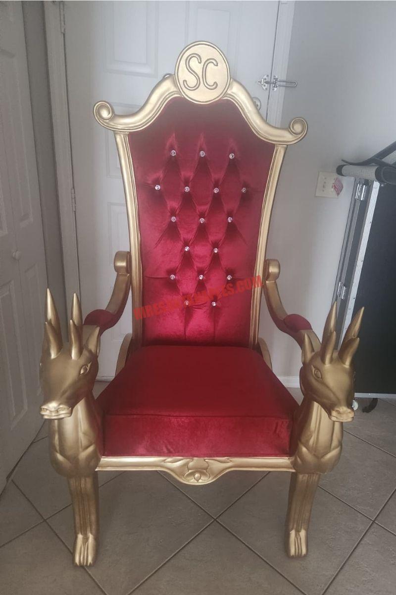 Santa chair photos in Naples, FL: gold chair with a red tufted back and reindeer armrests on beige tile.